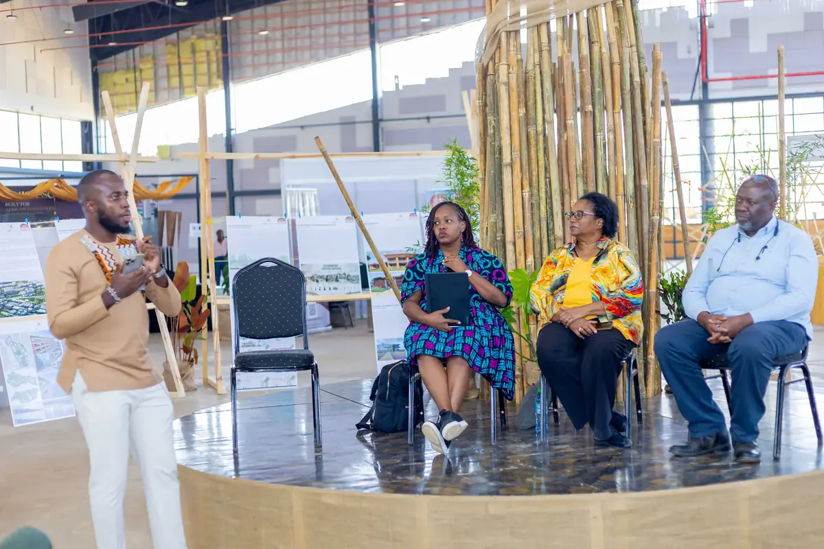 A panel discussion in the central arena beneath the bamboo tower